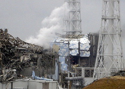 In this March 15, 2011 photo released by Tokyo Electric Power Co., smoke rises from the badly damaged Unit 3 reactor, left, next to the Unit 4 reactor covered by an outer wall at the Fukushima No. 1 nuclear complex in Okuma, northeastern Japan. (AP Photo/Tokyo Electric Power Co.)